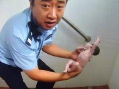 صور مؤثرة لشرطي صيني ينقذ رضيعة من الموت في دورة مياه عمومية