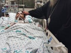 المطران عطا الله حنا يزور الشاب الجريح جميل بعبيش