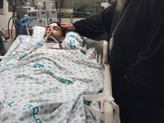 المطران عطا الله حنا يزور الشاب الجريح جميل بعبيش