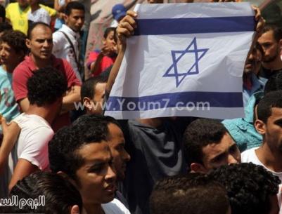 عدد من جماعة الاخوان يرفعون علم إسرائيل خلال مظاهرة في مصر