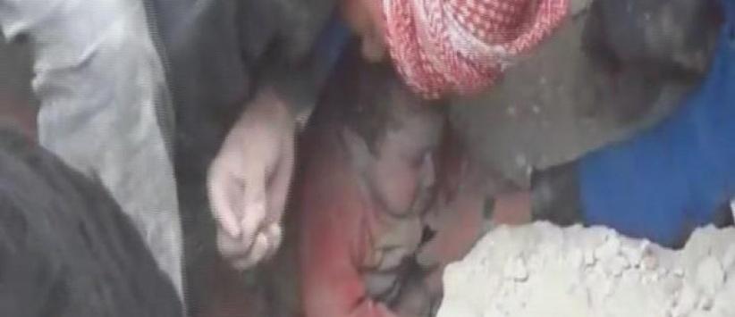 بالفيديو : طفلة سورية تخرج حية من تحت أنقاض مبنى سوي بالأرض