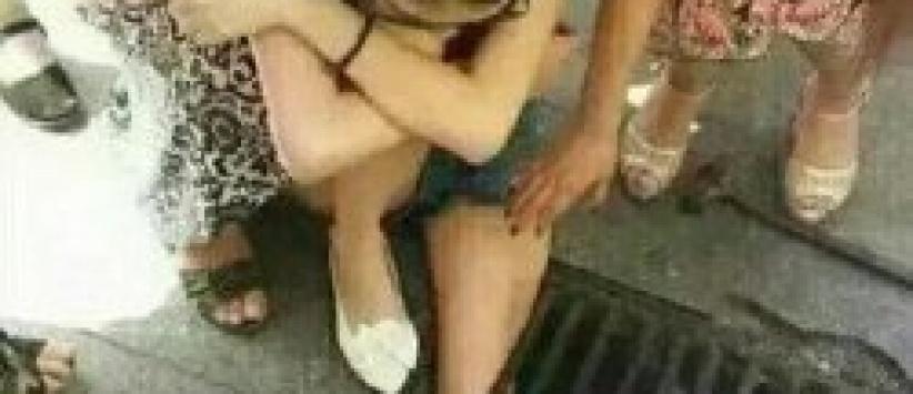 (صــورة) صينية تعلق داخل مصرف مياه لانشغالها بهاتفها المحمول