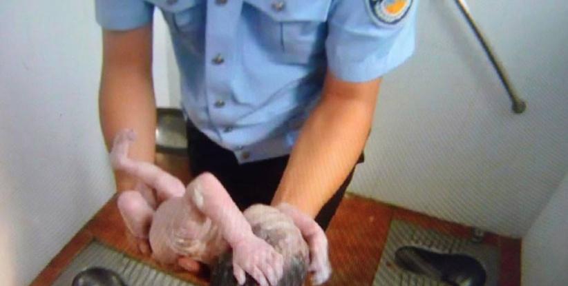 صور مؤثرة لشرطي صيني ينقذ رضيعة من الموت في دورة مياه عمومية