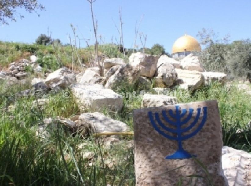 متطرفون يضعون شمعداناً إسرائيلياً على حجارة 