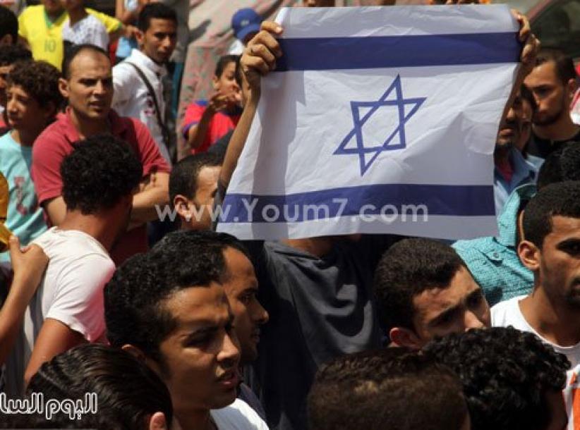 عدد من جماعة الاخوان يرفعون علم إسرائيل خلال مظاهرة في مصر