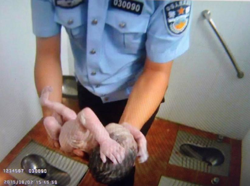 صور مؤثرة لشرطي صيني ينقذ رضيعة من الموت في دورة مياه عمومية