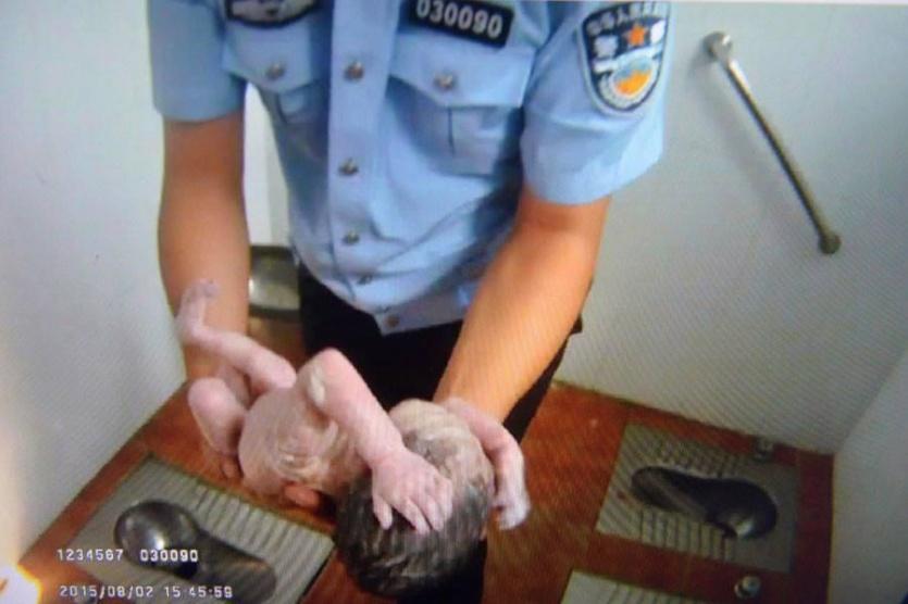 صور مؤثرة لشرطي صيني ينقذ رضيعة من الموت في دورة مياه عمومية