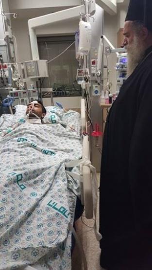 المطران عطا الله حنا يزور الشاب الجريح جميل بعبيش