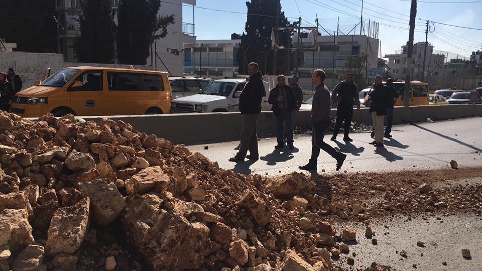 شبان يغلقون طريق قلنديا بالأتربة