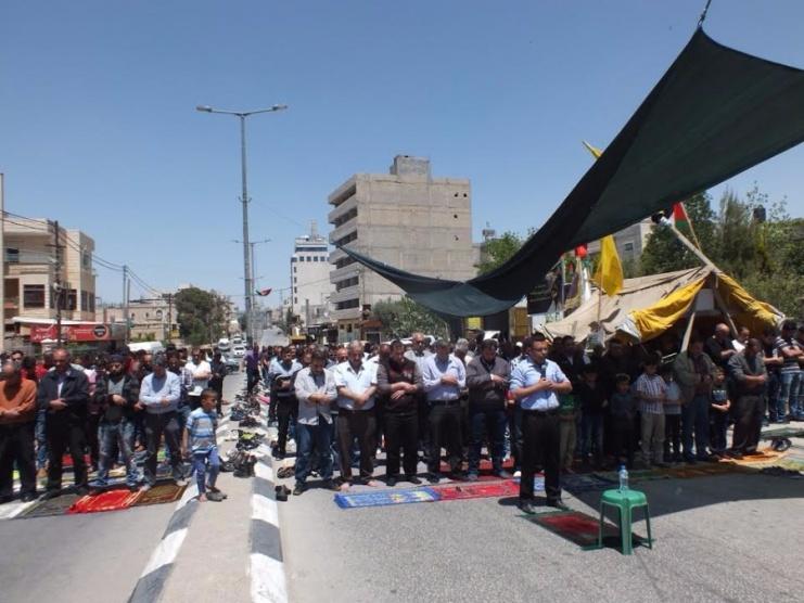مواطنون يؤدون الصلاة على مدخل بيت لحم الشمالي