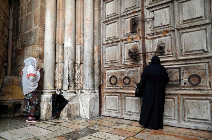 مسيحيون وسياح يؤدون صلواتهم على باب كنيسة القيامة المغلقة 